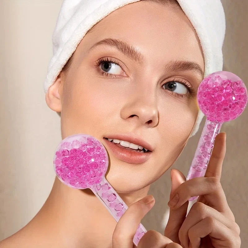 Woman holding pink facial rollers with a neutral background